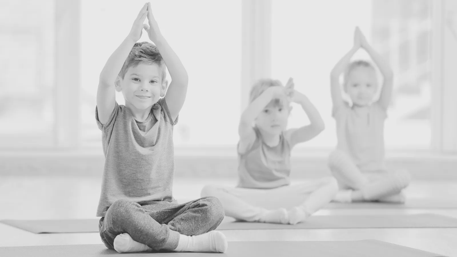 A child practicing a gentle, guided yoga pose as part of Orchid Academy's yoga therapy program.