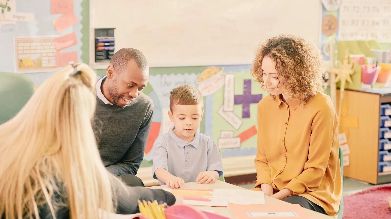 A family working with a teacher during a parent training session at Orchid Academy.