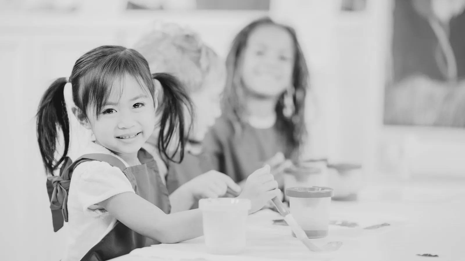 A young girl painting during an early intervention session.