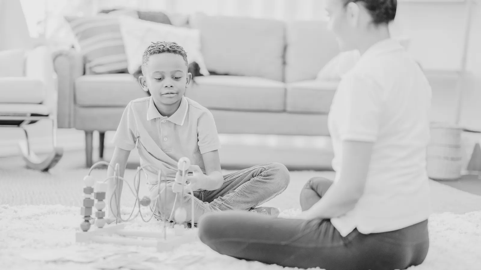A child playing on the floor during an ABA therapy session.